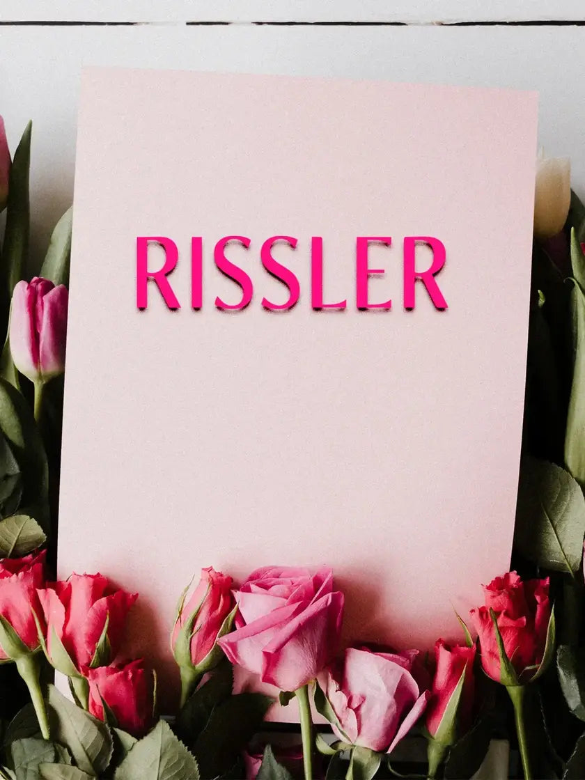 Le mot "Rissler" écrit sur une carte au milieu de roses