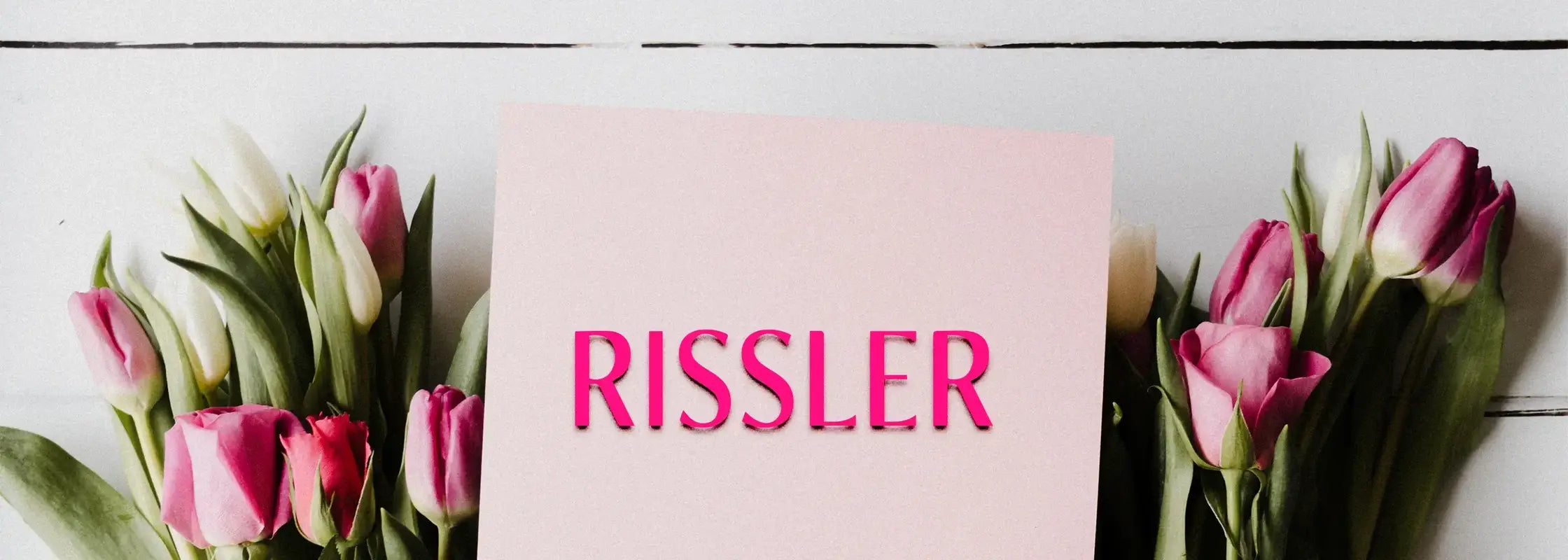 Le mot "Rissler" écrit sur une carte au milieu de roses