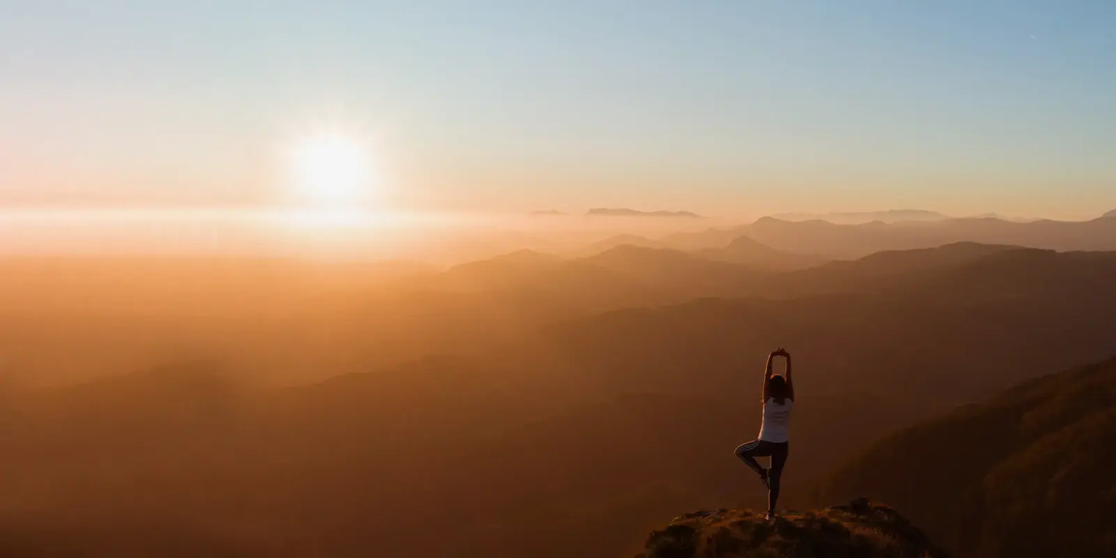 Une personne faisant du yoga dans les montagnes